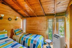 um quarto com 2 camas num chalé de madeira em Pura Vida em Ocean Bay Park