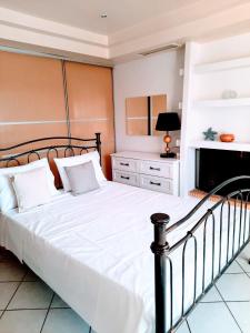 um quarto com uma grande cama branca e uma lareira em Ioannidis apartment em Psatha