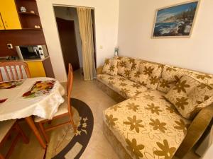 a living room with a couch and a table at Studios in Complex Colosseum in Kranevo