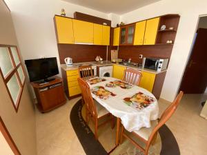 a small kitchen with a table and yellow cabinets at Studios in Complex Colosseum in Kranevo