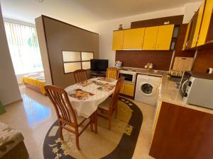 a kitchen with a table and chairs in a kitchen at Studios in Complex Colosseum in Kranevo