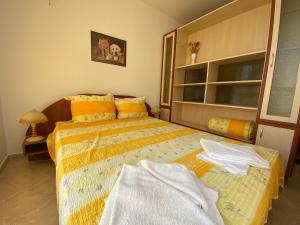 a bedroom with a bed with a yellow bedspread at Studios in Complex Colosseum in Kranevo