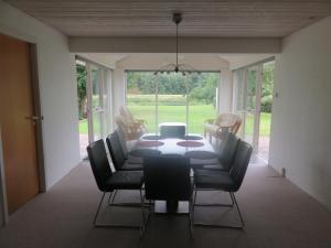 Gudená Riverview Villa في Bjerringbro: غرفة طعام مع طاولة وكراسي