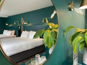 a mirror in a bedroom with a bed and a plant at The Rooms At Firecastle in Kildare