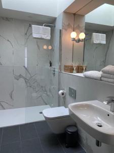a bathroom with a shower and a sink and a tub at The Rooms At Firecastle in Kildare