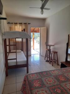a bedroom with a bunk bed and a table at Cachoeiras Pé da Serra in São João Batista do Glória