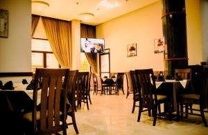 a dining room with tables and chairs and a tv at EL MOUSSAFIR HOTEL in Marrakech