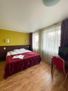 a bedroom with a red bed and a window at Bed and Breakfast Taurage Center in Tauragė