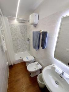a white bathroom with a sink and a toilet at Casa via della Rocca Luna in Poggibonsi