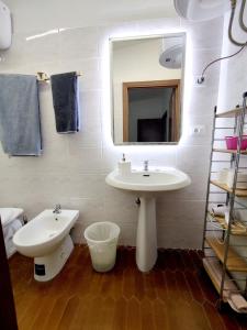 a bathroom with a sink and a mirror and a toilet at Casa via della Rocca Luna in Poggibonsi