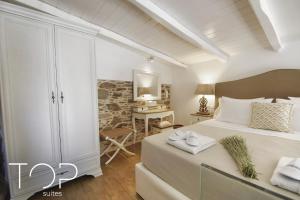 a bedroom with a king sized bed and a desk at TOP SUITES in Ermoupoli