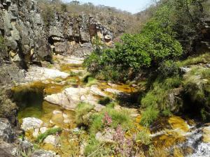 um riacho num desfiladeiro com rochas e árvores em Cachoeiras Pé da Serra em São João Batista do Glória