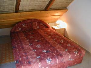 Schlafzimmer mit einem Bett mit einer roten Bettdecke in der Unterkunft Haus Veronika in Zamárdi + 30 Fotos