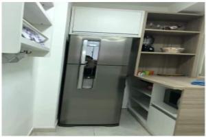 a stainless steel refrigerator in a small kitchen at Apto com Wi-Fi bem perto da praia em Santos SP in Santos