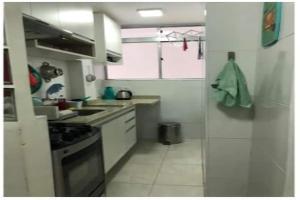 a small kitchen with a sink and a stove at Apto com Wi-Fi bem perto da praia em Santos SP in Santos