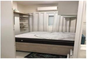 Ce lit superposé se trouve dans un dortoir blanc doté d'un canapé-lit. dans l'établissement Apto com Wi-Fi bem perto da praia em Santos SP, à Santos