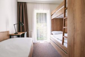1 Schlafzimmer mit 2 Etagenbetten und einem Fenster in der Unterkunft Galeria Apartments - Jasná in Demänovská Dolina