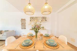 a dining room with a wooden table and chairs at Villa Cala Mesquida in Cala Mesquida