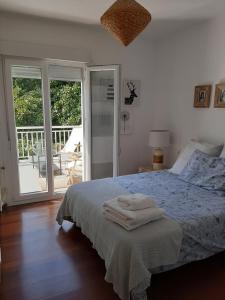a bedroom with a bed with two towels on it at Villa Pepe, casa compartida in Pontevedra
