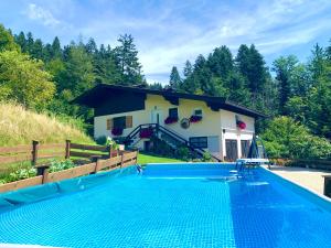 Villa con piscina frente a una casa en Sunnseit Lodge - Kitzbüheler Alpen en Sankt Johann in Tirol