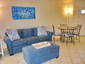 ein Wohnzimmer mit einem blauen Sofa und einem Tisch in der Unterkunft Estuary II 2071 in Marco Island