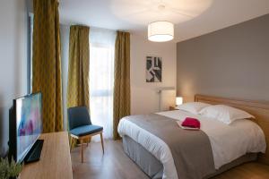 a hotel room with a bed and a television at DOMITYS LA SALAMANDRE in Vitry-le-François