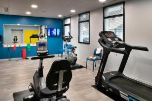 een fitnessruimte met een loopband en fitnessapparatuur in een kamer bij DOMITYS LA SALAMANDRE in Vitry-le-François