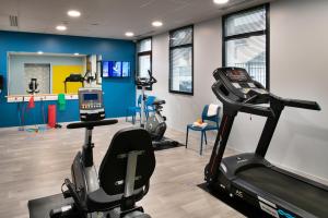 a gym with a treadmill and exercise equipment in a room at DOMITYS LA SALAMANDRE in Vitry-le-François