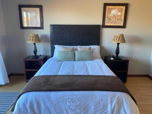 um quarto com uma cama grande e 2 candeeiros em Nimza K Guesthouse em Kimberley