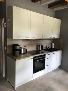 a kitchen with white cabinets and pots and pans at Fachwerk-Maisonette-Wohnung -zur Tenne- in Rieste