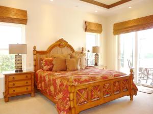 a bedroom with a large wooden bed and windows at Waterfront home with pool, spa and boating access in Marco Island +26 photos
