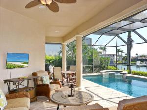 a living room with a pool and a ceiling fan at Waterfront home with pool, spa and boating access in Marco Island