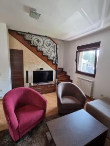 sala de estar con 2 sillas y TV en Apartman Aida Zlatibor, en Zlatibor