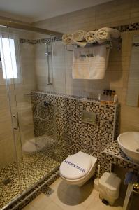 a bathroom with a shower and a toilet and a sink at Lydia Hotel in Rhodes Town