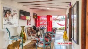 a room with chairs and a table and red doors at Casa Hotel Villa Marta in Jericó