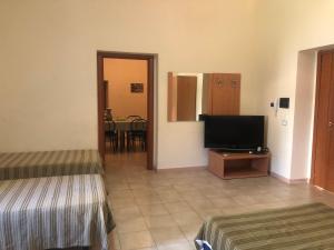 a room with two beds and a flat screen tv at Hostels Euro Mediterraneo in Rossano