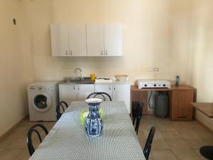 a kitchen with a table with a vase on it at Hostels Euro Mediterraneo in Rossano