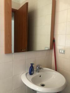 a bathroom sink with a mirror and a blue vase on it at Hostels Euro Mediterraneo in Rossano +33 photos