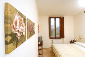 a bedroom with a large flower painting on the wall at Antica Dimora delle Acque in Cannara