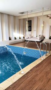 a swimming pool with a fountain in the middle of a room at شاليه كاردڤ1 in Al Baha