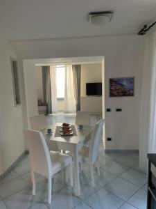 a white dining room with a table and chairs at Marechiaro Home Holiday in Vico Equense