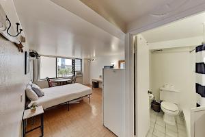een woonkamer met een bed en een badkamer bij Hawaiian Monarch 801 condo in Honolulu