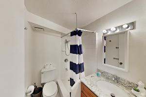 een witte badkamer met een toilet en een wastafel bij Hawaiian Monarch 801 condo in Honolulu