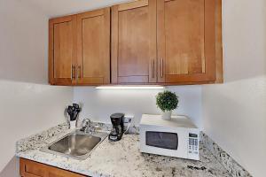 a kitchen counter with a sink and a microwave at Hawaiian Monarch 801 condo in Honolulu