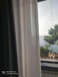 a curtain in a window with wine glasses at Marechiaro Home Holiday in Vico Equense