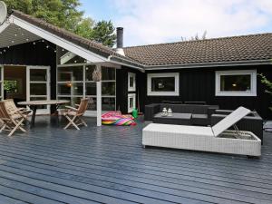 una terrazza in legno con divano e tavolo di 8 person holiday home in Vejby a Vejby
