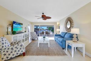 a living room with a blue couch and a table at Waterfront home with pool and foosball table in Marco Island