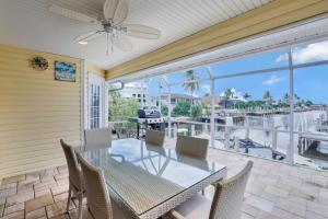 a dining room with a table and chairs on a balcony at Waterfront home with pool and foosball table in Marco Island