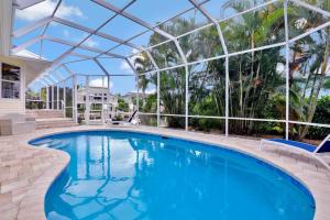 a large swimming pool with a glass roof at Waterfront home with pool and foosball table in Marco Island