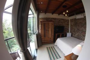 a bedroom with a bed and a brick wall at ATLANTIC FOREST HOUSE AT FOREST in Angra dos Reis